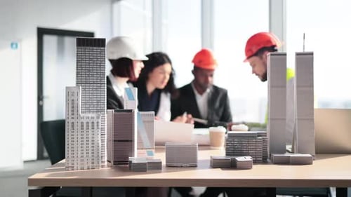 Architects Collaborate Over Building Models in Office