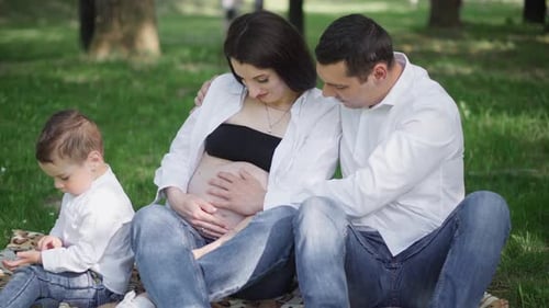Une jeune famille heureuse se repose dans le parc