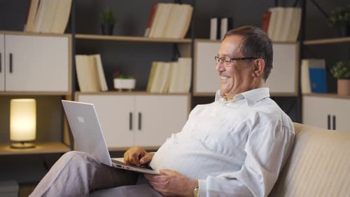 Mature Man Enjoys Laptop on Comfortable Couch