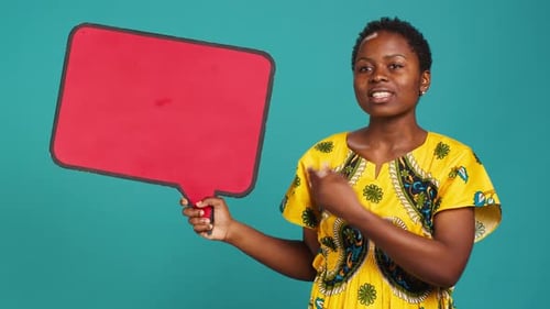 Smiling Person Showing a Red Isolated Speech Bubble in Studio