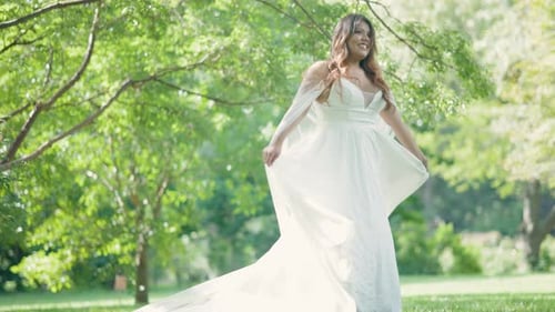 Woman in White Dress Twirling in Grassy Meadow