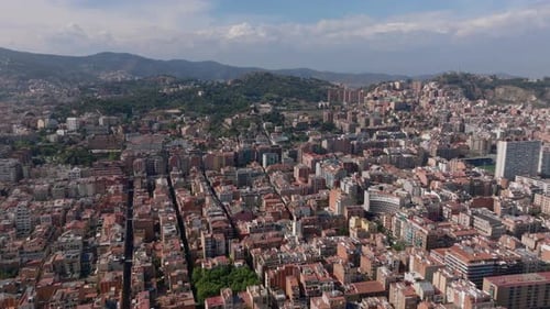 Forwards Fly Above City Buildings in Urban Boroughs and Wooded Hills in Background Barcelona Spain