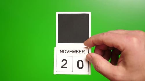 Hand Turns Block Calendar Displaying November 20th