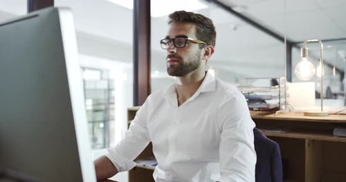 Séquence vidéo 4k d'un beau jeune homme d'affaires travaillant dans son bureau
