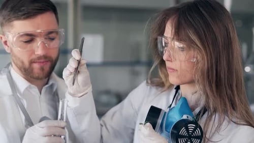closeup portrait scientists man and woman in glasses taking tweezers stuff for research