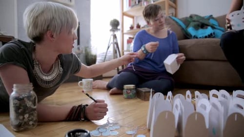 Women Crafting Together on Wooden Floor in Home