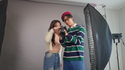 Asian beautiful woman model and cameraman working in photography studio.