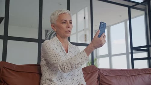 Senior Woman Using Smartphone for Video Call at Home