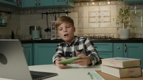 Kid Playing Mobile Games Instead of Doing Homework at Home