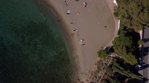 Drone view from above of a beautiful beach with turquoise water with people sunbathing and playing,