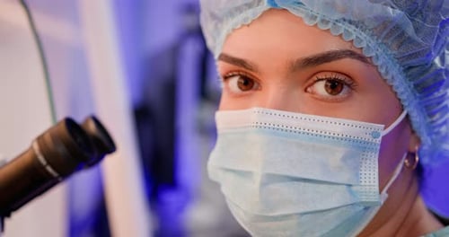 Woman Scientist Using Microscope in Medical Lab