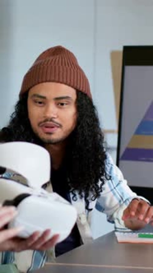 Vidéo verticale : réception du casque d'un collègue Beanie Man testant la réalité virtuelle pour une démonstration à une table de réunion