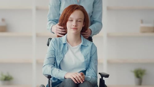 Loving Mother Supporting Teen Daughter in Wheelchair