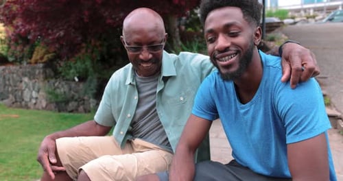 Smiling Man and Young Adult Outside Home Together