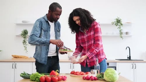 Couple Making Salad in Kitchen with Fresh Vegetables
