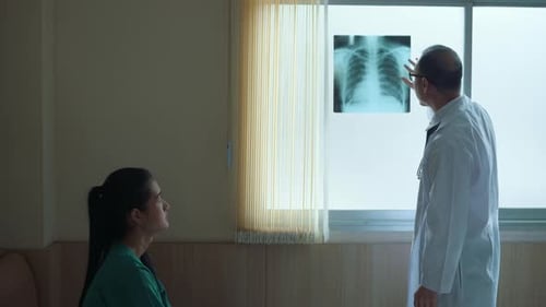 Doctor Explains X-Ray to Patient in Hospital Room