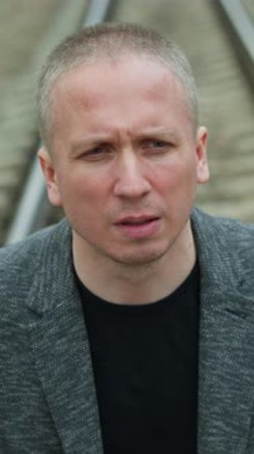 Adult Man in Gray Jacket Looking at Camera