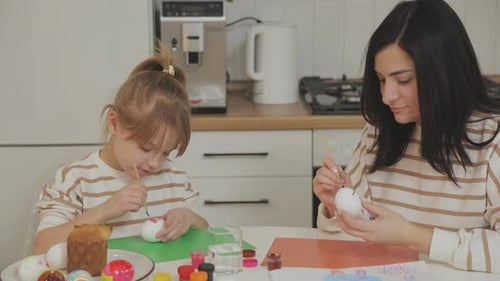 Mother and Daughter Painting Easter Eggs at Home