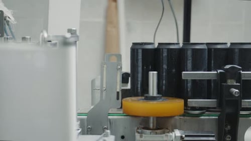 Black aluminum cans moving on conveyor belt in bottling factory