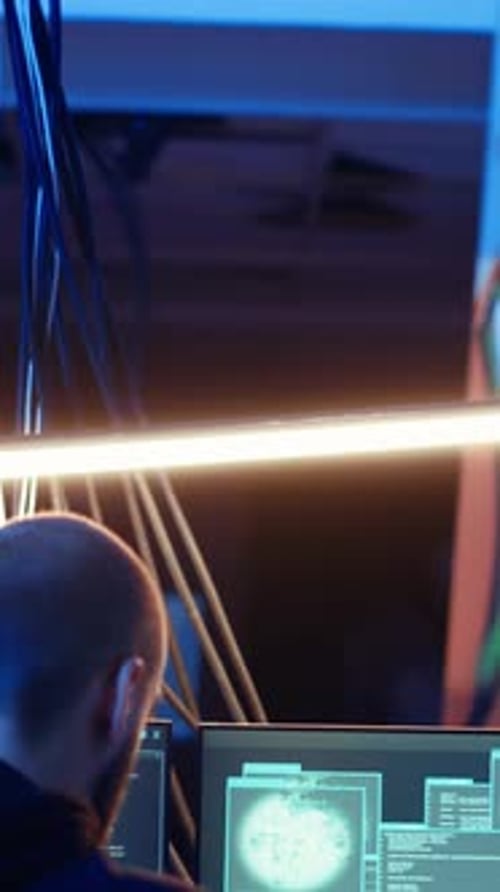 Un hacker de vídeo vertical en un refugio oculto escucha música mientras lanza ataques DDoS
