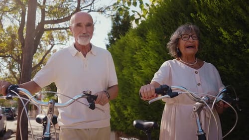 Senior Couple Strolling with Bicycles on a Sunny Day