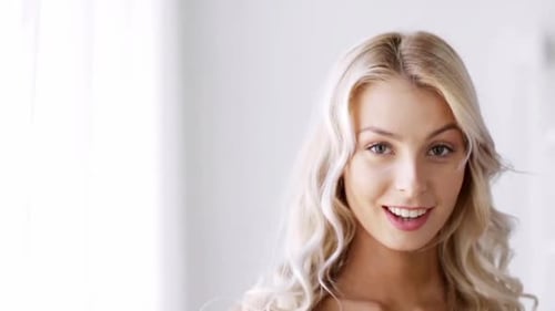 Joven sonriente se toca el pelo en un juguetón retrato en cámara lenta