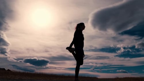 Beautiful black silhouette outline of a female jogger stretching her legs before a run. She alterna
