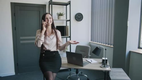 Business Lady in a Business Suit Talking on the Phone in the Office