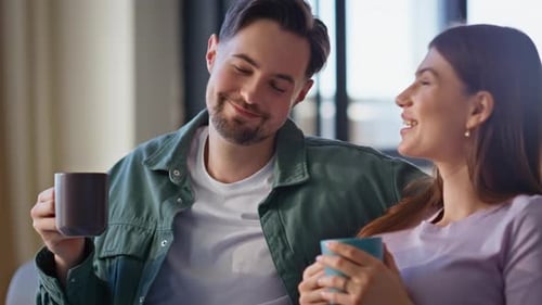 Happy Young Couple Relaxing Together and Drinking Coffee