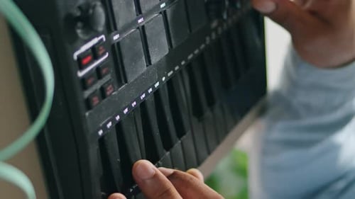 Man Playing Black Midi Keyboard in Home Studio