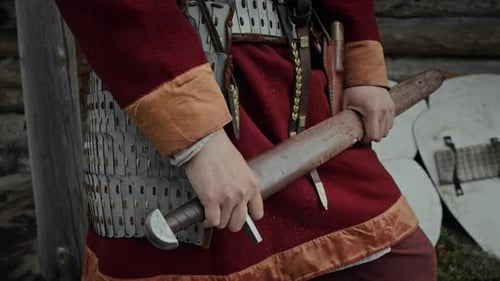 Anonymous Male Warrior in Armour Holding Wooden Sparring Sword