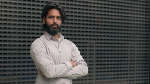 Man With Beard Stands Against Textured Wall