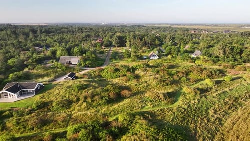 Aerial view of holiday homes in Lodbjerg Hede, Denmark, nestled in heathland landscapes with lush gr
