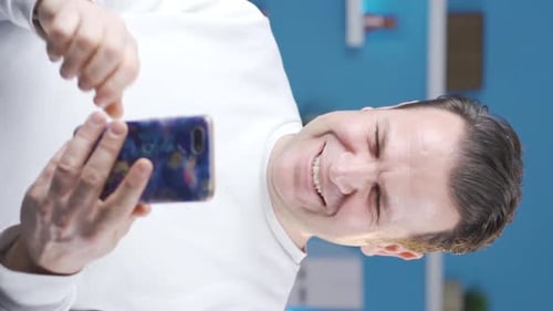 Man Smiling and Using a Smartphone Device