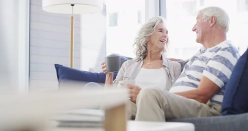 Senior Couple Laughing Together on Couch at Home