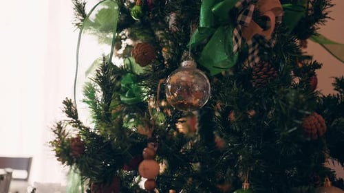 Green Christmas Tree Decorated With Ornaments and Ribbons
