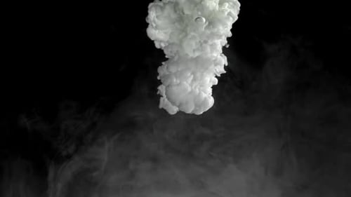 White Ink Clouds Dissolving Underwater on Black Background