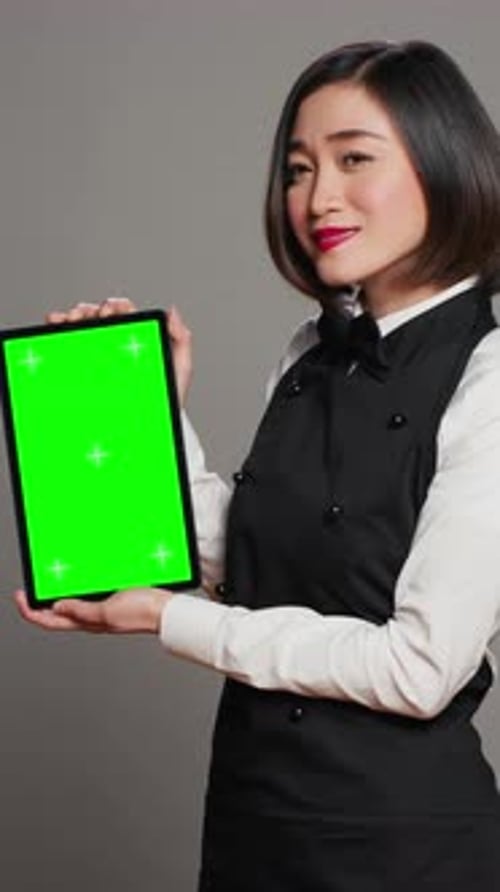 Vertical Video Asian Restaurant Hostess Showing Greenscreen Display in Studio