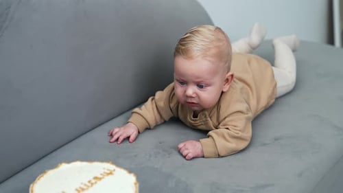 Baby Reaches for a Birthday Cake on Couch