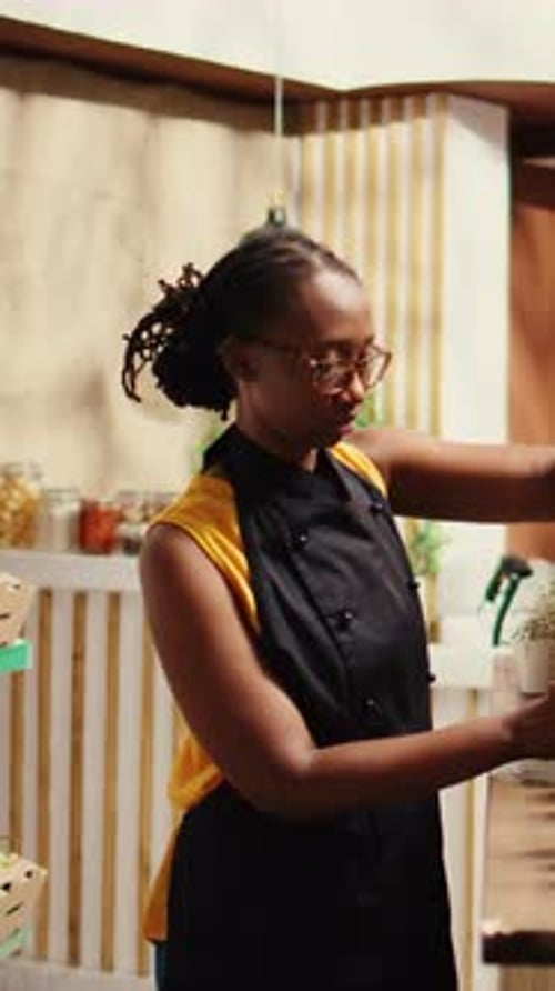Smiling Employee in Cafe Workplace with Black Apron