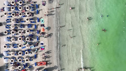 Aerial view on beach, people and umbrellas. Vacation and adventure. Europe, Mediterranean Sea.