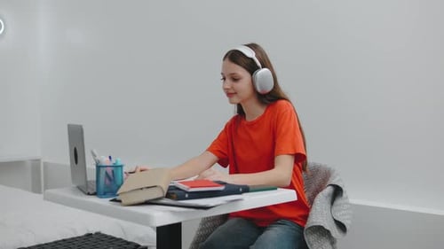 A Teenage Girl in Headphones Turns on Music on Her Smartphone and Starts Dancing and Singing In a
