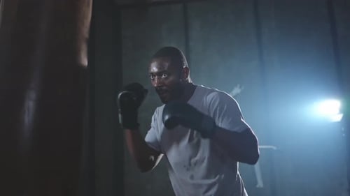 Fitness Workout in Gym Strong African Man Fighter Training Punches with Boxing Bag Healthy Boxer Man