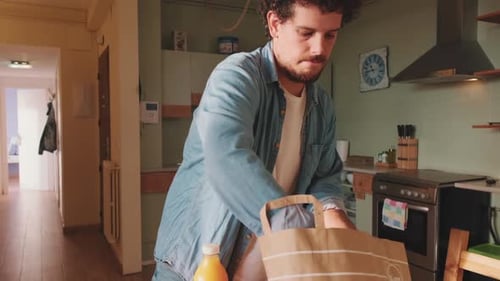 Man Unpacks Groceries in Sunny Kitchen