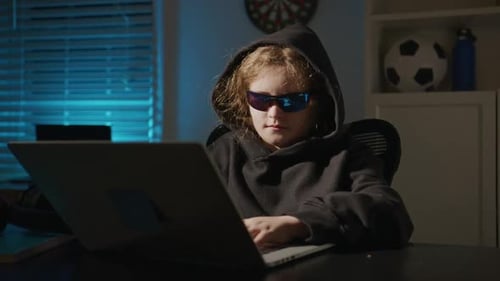 Kid Hacker Wearing Hoodie Indoors Kid Hacker Typing Fast on Keyboard Kid Hacker Studying Coding