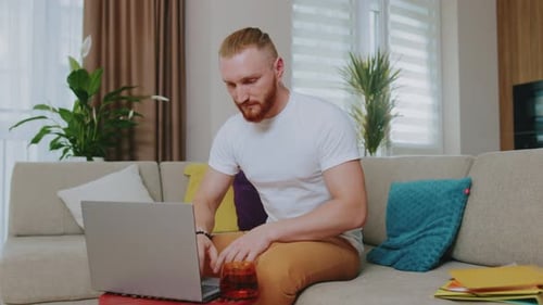 Man Using Laptop at Home During the Daytime