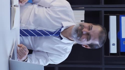 Man at Desk Celebrating Success in Office