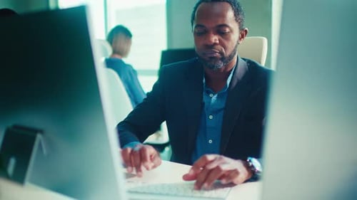 Businessman Typing on Keyboard in Modern Office Workspace
