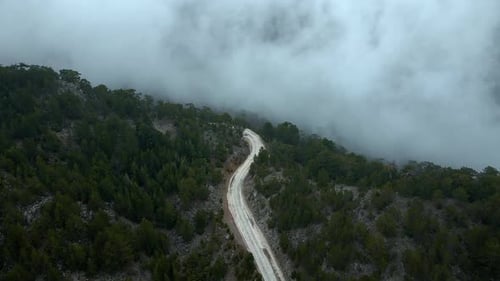 Vue aérienne Le ciel est nuageux et les montagnes et la route sont couvertes de brouillard