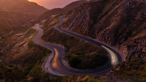 Time Lapse nocturno de una carretera que serpentea entre las montañas